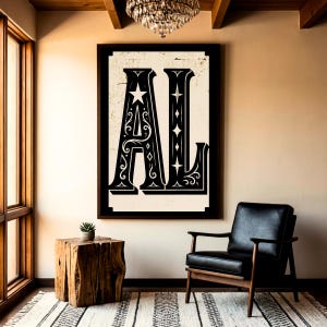 Könnte beinhalten: Ein gerahmter Schwarz-Weiß-Druck mit den Buchstaben "AL" in einem dekorativen, Vintage-Stil. Das Kunstwerk wird in einem Raum mit einem schwarzen Ledersessel, einem hölzernen Beistelltisch und einem gemusterten Teppich ausgestellt. Ein Kronleuchter hängt von der Decke.