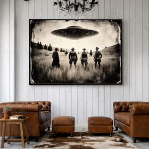 May include: Sepia-toned framed print depicting cowboys facing a hovering UFO in a field. The image has a vintage aesthetic, with the cowboys in hats and the spacecraft detailed with lights. The artwork is displayed above leather furniture.