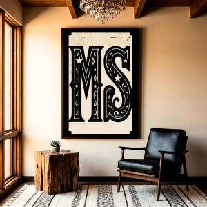 Könnte beinhalten: Schwarz-weiß gerahmtes Wandbild mit den Buchstaben "MS" in einem dekorativen, Vintage-Stil. Das Kunstwerk hängt über einem schwarzen Ledersessel und einem hölzernen Beistelltisch. Der Raum hat eine neutrale Farbpalette mit einem Teppich und einem Kronleuchter.