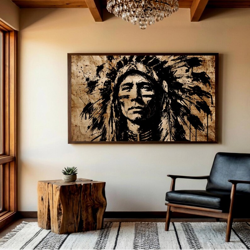 May include: A rectangular wall art piece featuring a high-contrast black ink illustration of a person wearing a traditional feathered headdress on a textured beige background, displayed in a dark brown wooden frame on a plain wall.