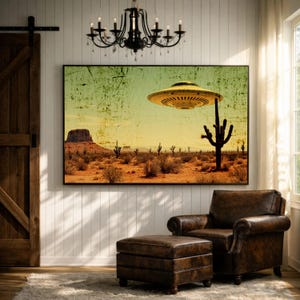 May include: A framed art print depicts a desert landscape with a yellow flying saucer hovering above cacti and mesas. The artwork has a vintage, distressed look, with a color palette of yellow, brown, and green. The print is displayed above a leather armchair and ottoman.