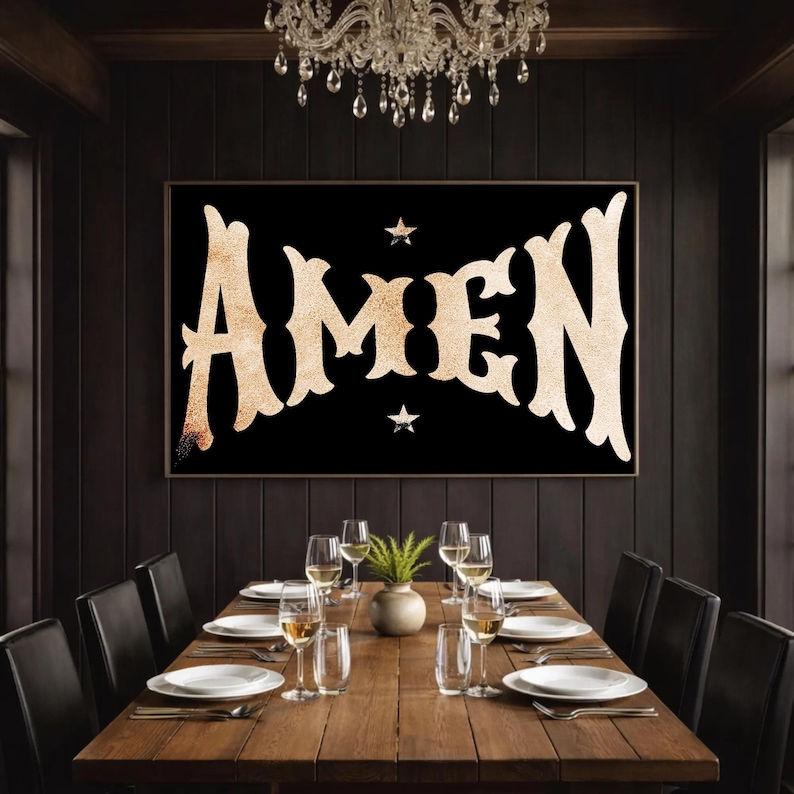 May include: A dining room scene featuring a large framed artwork with the word "AMEN" in a vintage, ornate font against a black background. Two small stars flank the word. A wooden dining table is set with white plates, glasses, and silverware, with a small plant centerpiece.