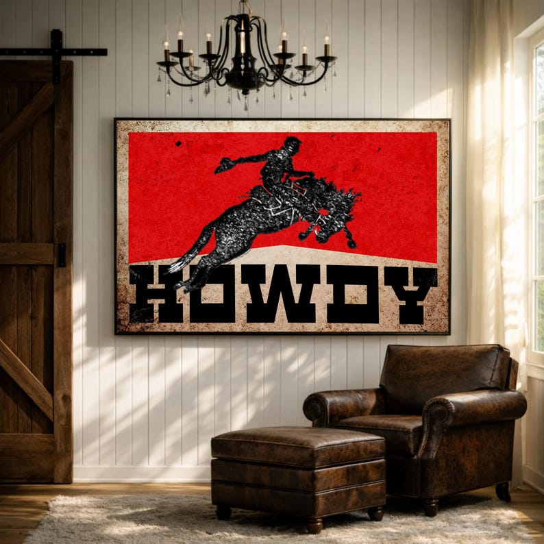 May include: A framed art print featuring a rodeo scene with a cowboy riding a bucking bronco against a red background. The word "HOWDY" is displayed in bold, black letters. The artwork has a distressed, vintage aesthetic.