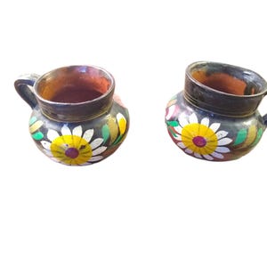 May include: A set of three ceramic mugs with a speckled, matte finish. The mugs are in shades of cream, light brown, and dark brown. Each mug has a simple, minimalist design, perfect for coffee or tea.