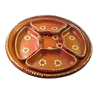 May include: A handcrafted, terracotta serving tray with a central round section and four surrounding compartments. The tray is painted in shades of brown and red, with white and yellow floral accents. The rim has a decorative white dotted pattern.