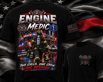 Op de afbeelding: Een zwart t-shirt met een afbeelding van een brandweerman in uitrusting die medische tassen draagt voor een brandweerwagen. De tekst luidt ENGINE MEDIC, FIRE TODAY, EMS TOMORROW, ALWAYS READY en TWO CALLS. ONE CREW. ONE MISSION. Klein logo op de voorzijde.