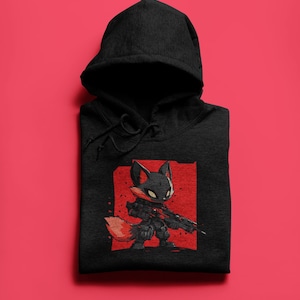 Puede incluir: Sudadera con capucha negra con un gráfico rojo y negro de un zorro sosteniendo un rifle. El zorro lleva un casco negro y tiene una cola roja.