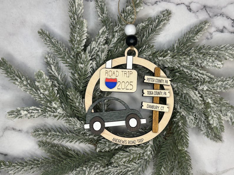 Add a touch of charm to your Christmas tree with our laser engraved wood road trip ornament. Handcrafted with love, this unique piece captures the essence of adventure. Perfect for travel enthusiasts and wanderlust souls! A wonderful gift for anyone who loves hitting the open road. We can add up to 7 locations on this ornament to customize this to your favorite adventure. Order yours today!