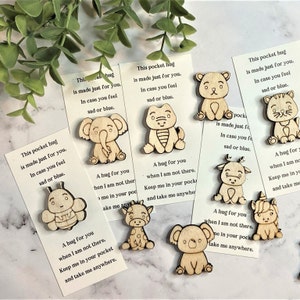 May include: A set of ten wooden pocket hug tokens, each featuring a different animal design. The tokens are accompanied by small cards with messages about hugs and being there for someone when they are feeling sad or blue.