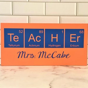 Teacher desk name plate for your best science teacher!  Chemistry teacher, Biology teacher or principal.  This custom wood sign measures approx. 5 1/4"x11" and states:

TeAcHEr
Teacher's Name