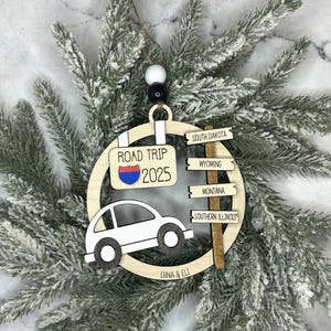 Add a touch of charm to your Christmas tree with our laser engraved wood road trip ornament. Handcrafted with love, this unique piece captures the essence of adventure. Perfect for travel enthusiasts and wanderlust souls! A wonderful gift for anyone who loves hitting the open road. We can add up to 7 locations on this ornament to customize this to your favorite adventure. Order yours today!