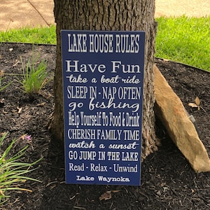 Custom wood sign measures approx. 11 1/4 x 23 inches and states: 

Lake House Rules
Have Fun
Take A Boat Ride
Sleep In - Nap Often
Go Fishing
Help Yourself To Food & Drink
Cherish Family Time
Watch A Sunset
Go Jump In The Lake
Read - Relax - Unwind