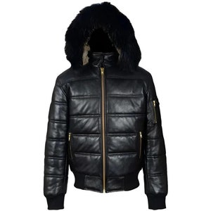 Puede incluir: Una chaqueta acolchada de cuero negro con costuras horizontales, una cremallera central dorada y una capucha forrada con piel sintética negra gruesa. La chaqueta incluye puños y dobladillo acanalados, además de bolsillos laterales con cremallera.