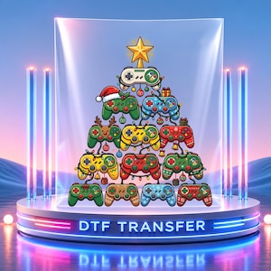 May include: A DTF transfer graphic featuring a Christmas tree composed of various colorful video game controllers. The controllers are decorated with holiday lights, ornaments, and a Santa hat, topped with a yellow star. The design is displayed on a circular platform.