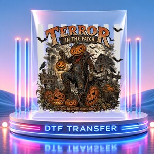 Peut inclure: Une feuille de transfert DTF avec un graphique d'un épouvantail à tête de citrouille tenant une lanterne dans un champ. Le texte indique TERROR IN THE PATCH, MIDNIGHT HARVEST et THE HARVEST HUNTS BACK. La scène inclut des chauves-souris, une grange et un moulin.