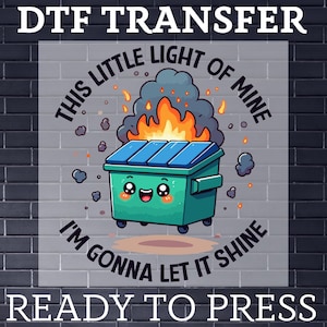 May include: DTF transfer featuring a cartoon dumpster on fire with the text "THIS LITTLE LIGHT OF MINE I'M GONNA LET IT SHINE READY TO PRESS". The dumpster is teal with a blue lid and has a smiling face.