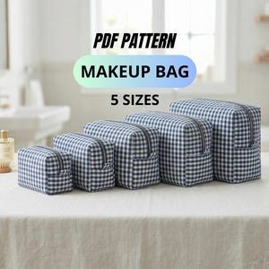 Puede incluir: Un conjunto de cinco neceseres de maquillaje de diferentes tamaños, dispuestos de menor a mayor. Cada neceser presenta un estampado de cuadros vichy azules y blancos, cierre de cremallera y un pequeño bolsillo. El texto "PDF PATTERN MAKEUP BAG 5 SIZES" está encima.