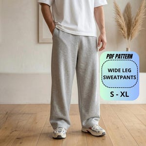 Puede incluir: Pantalones de chándal gris claro de pierna ancha con diseño liso. La imagen incluye el texto PDF PATTERN WIDE LEG SWEATPANTS S - XL. Los pantalones presentan un corte holgado y se combinan con una camiseta blanca lisa y zapatillas deportivas.
