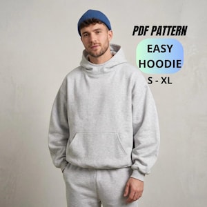 May include: A person wearing a grey hoodie and matching tracksuit bottoms, with a blue beanie. The image includes text that reads "PDF PATTERN EASY HOODIE S-XL". The hoodie has a front pocket.