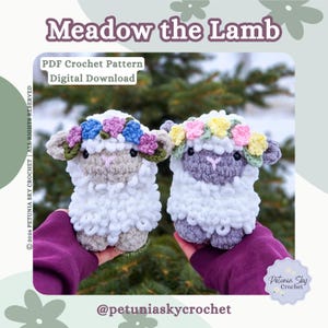 May include: Two handmade crochet lambs, each with a floral crown. The lambs are white with grey and purple accents. The text "Meadow the Lamb" and "PDF Crochet Pattern Digital Download" are visible.