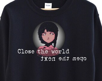 May include: Black sweatshirt with a graphic of a girl with dark hair and red eyes inside a circle. The text "Close the world, open the next" is printed in white below the graphic. The sweatshirt is hanging on a wooden hanger.