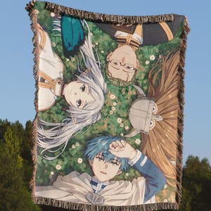 May include: A rectangular woven throw blanket featuring a colourful anime-style illustration of four characters lying in a field of green grass and small white flowers. The blanket has a decorative fringed edge on all sides and a textured fabric finish.