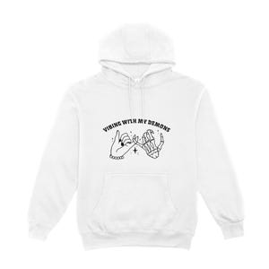 May include: White hoodie with a black graphic of two hands holding pinky fingers. The text "Vibing with my demons" is above the graphic.