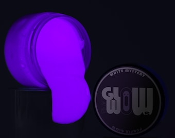 Könnte beinhalten: Ein Glas mit violetter, im Dunkeln leuchtender Farbe mit den Worten "THAT GLOW" und "WHITE MYSTERY" auf dem Deckel.