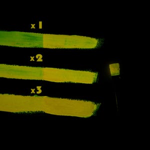 Orange glow in the dark paint glowing green under blacklight, phosphorescent test showing layer strength for toy or necklace crafting
