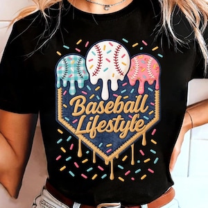 Könnte beinhalten: Schwarzes T-Shirt mit einem Baseball-Motiv. Das Design zeigt drei Basebälle, die wie Eiscreme schmelzen, über den Worten "Baseball Lifestyle" auf einem denimartigen Aufnäher, mit bunten Streuseln.