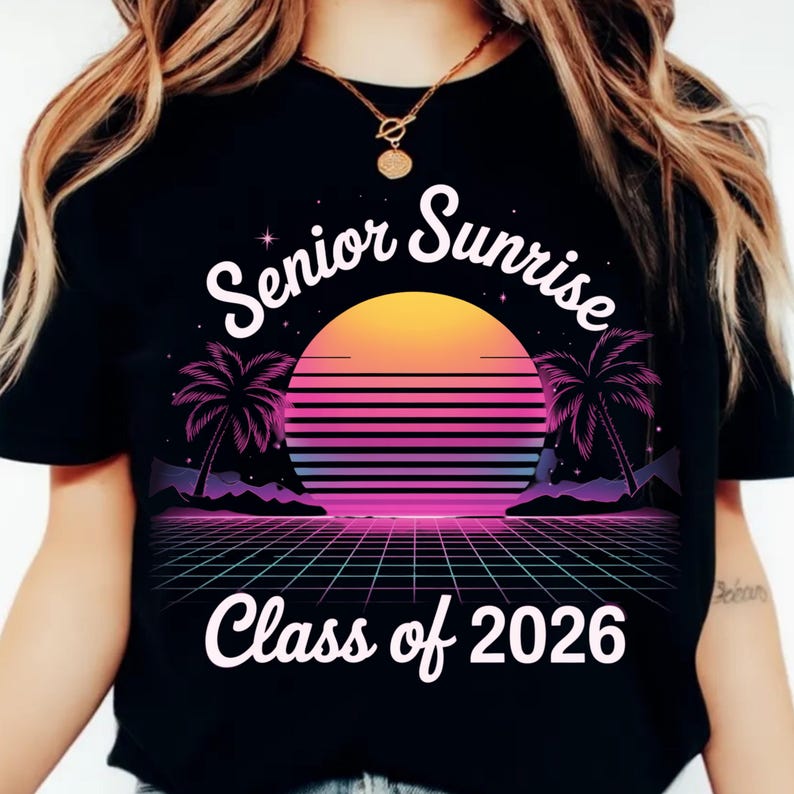K&ouml;nnte beinhalten: Schwarzes T-Shirt mit Retro-Design, das einen Sonnenuntergang, Palmen und ein Gittermuster zeigt. Der Text "Senior Sunrise" w&ouml;lbt sich &uuml;ber der Sonne, darunter "Class of 2026". Das Design ist in Orange-, Rosa-, Lila- und Blaut&ouml;nen gehalten.
