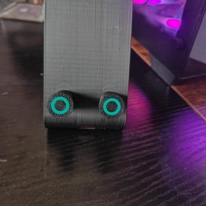 K&ouml;nnte beinhalten: Ein schwarzes, rechteckiges Ger&auml;t mit zwei kreisf&ouml;rmigen, gr&uuml;n umrandeten Elementen. Das Ger&auml;t befindet sich auf einer dunklen Oberfl&auml;che, im Hintergrund ist ein Laptop zu sehen. Das Bild enth&auml;lt den Text "OPPO Find X5" und "HASSELBLAD".