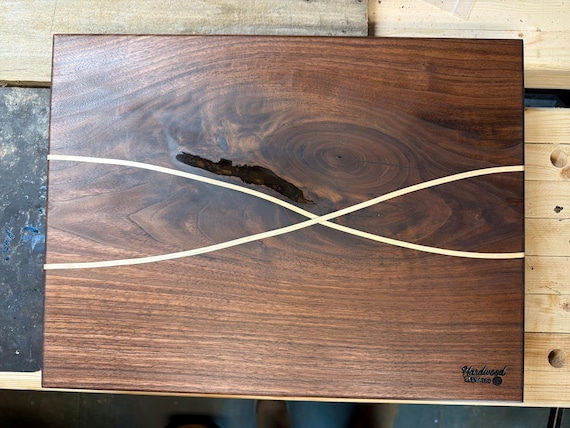 A one-of-a-kind black walnut board with a contrasting maple inlay — functional art that doubles as a centerpiece charcuterie board.