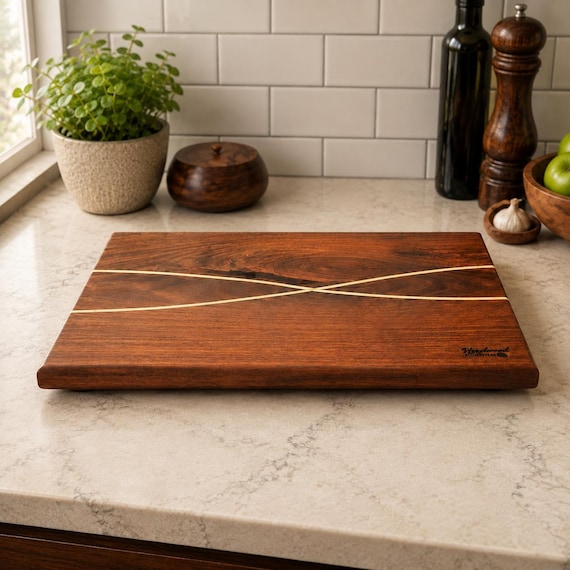 A one-of-a-kind black walnut board with a contrasting maple inlay — functional art that doubles as a centerpiece charcuterie board.