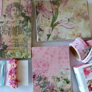 May include: A collection of pink and green floral patterned paper, pink patterned paper, and washi tape rolls. The washi tape rolls are in various colors and patterns. The paper is perfect for scrapbooking, card making, and other craft projects.