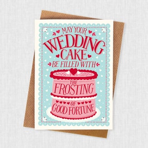 May include: A light blue card with a white border and a pink and red wedding cake illustration. The text reads "May your wedding cake be filled with the frosting of good fortune."