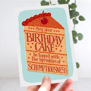 May include: A birthday card with a colorful illustration of a slice of cake with a cherry on top. The text reads "May your birthday cake be topped with the sprinkles of scrumptiousness."