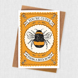 May include: A yellow and white card with a black and yellow bumblebee illustration. The card says "You're cuter than a bee's bum".
