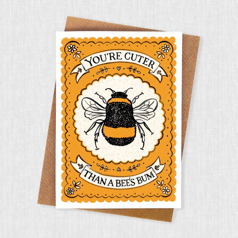 May include: A yellow and white card with a black and yellow bumblebee illustration. The card says "You're cuter than a bee's bum".