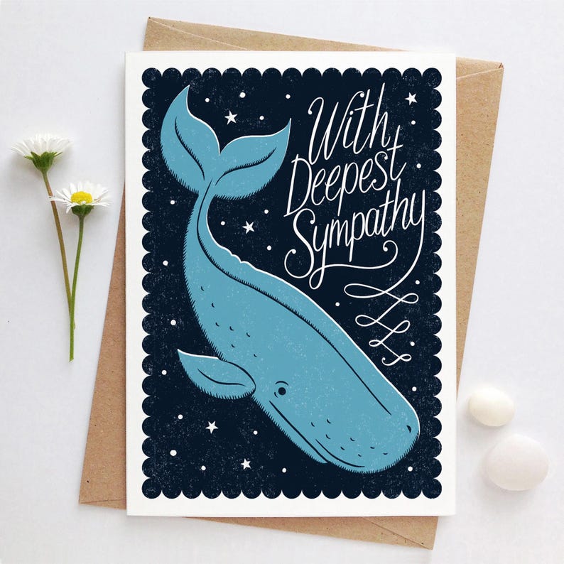 May include: A sympathy card with a blue whale illustration on a dark blue starry background. The card reads "With Deepest Sympathy" in elegant script. The card is on a brown envelope.