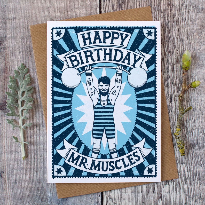 Pu&ograve; includere: Un biglietto di auguri di compleanno blu e bianco con un'illustrazione di un uomo forte che solleva pesi. Il biglietto dice "Buon compleanno Mr. Muscles".