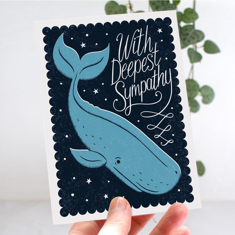 May include: A sympathy card with a blue whale illustration on a dark blue background with white stars. The card reads "With Deepest Sympathy" in white script. The card has a scalloped border.