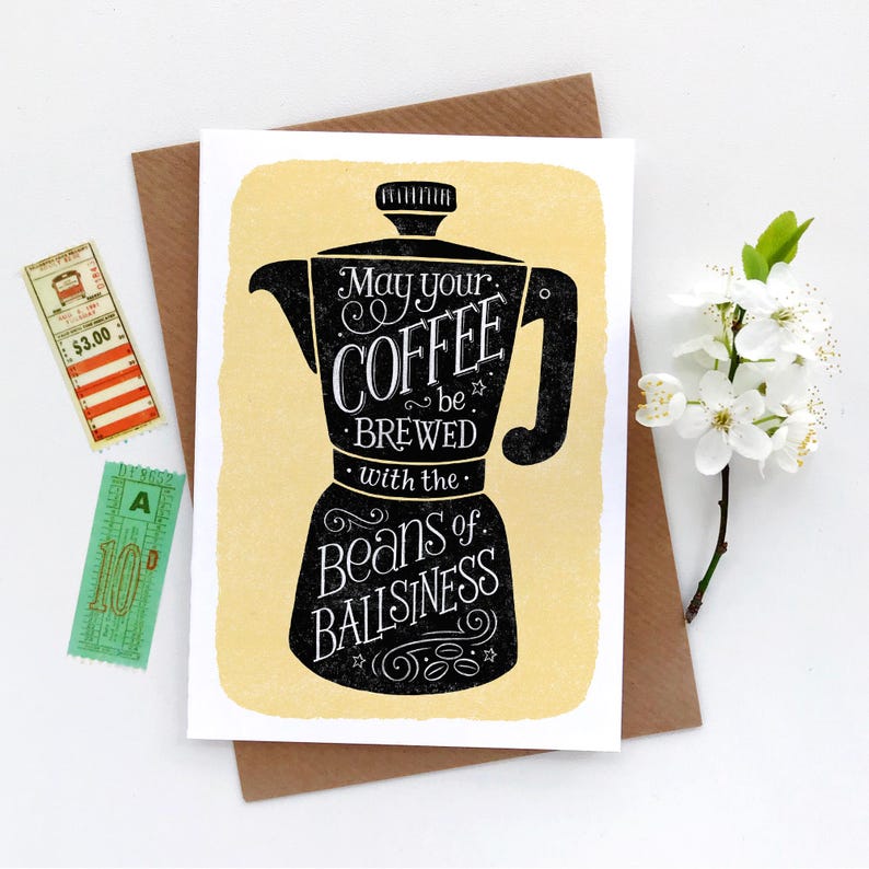 May include: A yellow card with a black illustration of a coffee pot and the text "May your coffee be brewed with the beans of ballsiness."