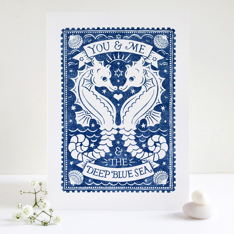 K&ouml;nnte beinhalten: Eine blaue und wei&szlig;e illustrierte Karte mit zwei Seepferdchen, die sich gegen&uuml;berstehen und ein Herz bilden. Der Text lautet "You & Me & The Deep Blue Sea".