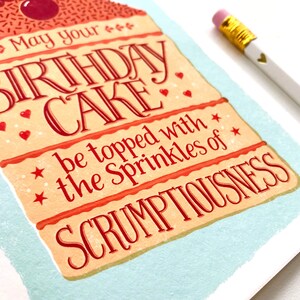 May include: A birthday card with a layered cake illustration. The card reads "May your birthday cake be topped with the sprinkles of scrumptiousness."