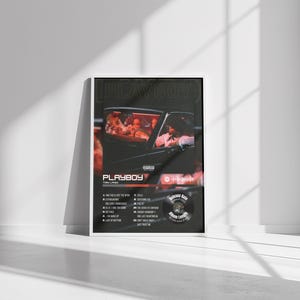 May include: A framed poster featuring a car with people inside. The poster has the word "PLAYBOY" at the top, with a list of song titles and a record label logo. The image has a vintage aesthetic with a red and black color scheme.