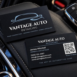 May include: Two black business cards for Vantage Auto Detailing. One card shows a car outline logo and services. The other displays the name James Mitchell, contact details, a QR code labelled Scan to Book, and the text The Art of Automotive Care.