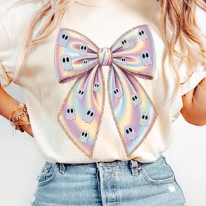 Pastel holographic bow PNG decorated with cute white ghosts. The bow features soft rainbow colors including pink, blue, yellow, and lavender. The design has a glossy shimmer effect, giving it a girly Halloween vibe. Ideal for sublimation and digital crafts.