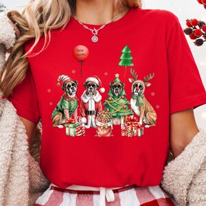 Festive Christmas design featuring four boxer dogs in holiday costumes. The boxer dogs are dressed as Santa Claus, a reindeer, a Christmas tree, and an elf, surrounded by Christmas gifts and decorations. High-quality digital PNG with transparent background, perfect for sublimation projects, holiday crafts, T-shirts, mugs, and unique Christmas gifts for boxer lovers and pet owners. Bright, detailed artwork that captures the joy of the holiday season.
