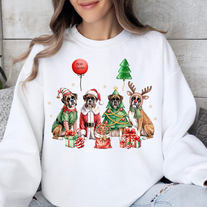 Pu&ograve; includere: Felpa bianca con un design a tema natalizio. Mostra quattro cani Boxer in abiti festivi: un elfo, Babbo Natale, un albero di Natale e una renna. Un palloncino rosso mostra la scritta "Merry Christmas".
